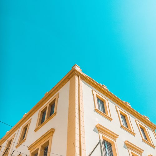 worm's-eye view photography of yellow and brown concrete house under clear sky
